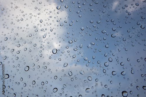 drop of water on window glass, cloud and blue sky background