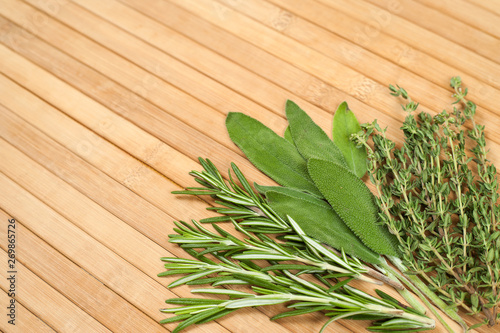 Collection of fresh herbs for cooking isolated on wooden background. Bunch of herbs