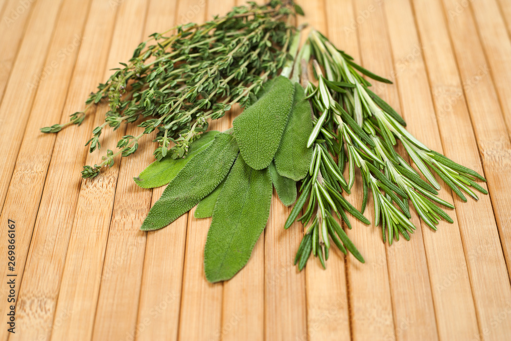 Collection of fresh herbs for cooking isolated on wooden background. Bunch of herbs