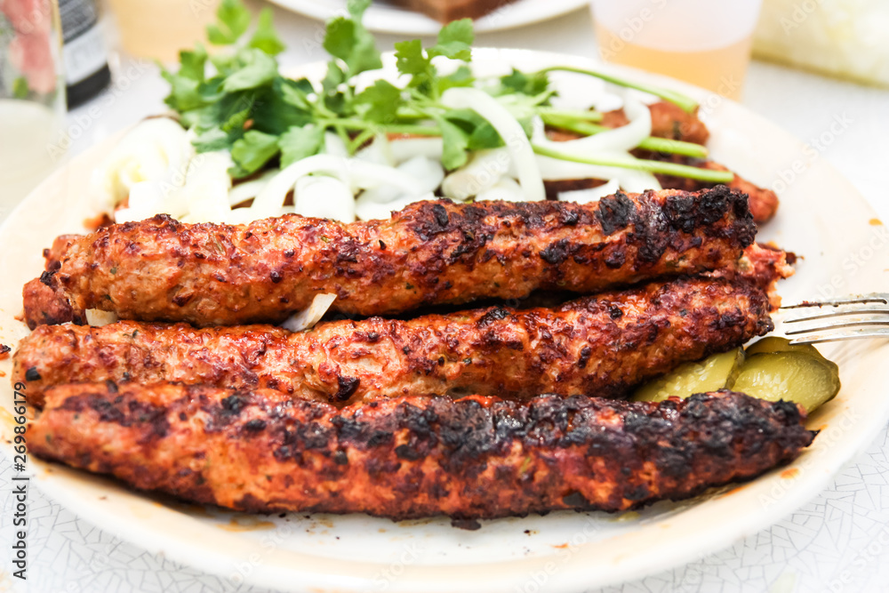 grilled lula kebab with herbs and onions on a plate grilled lula kebab with herbs and onions on a plate