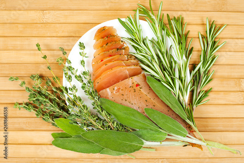 Sirloin meat with fresh rosemary, sage and thyme on a wooden table.  View from above. photo