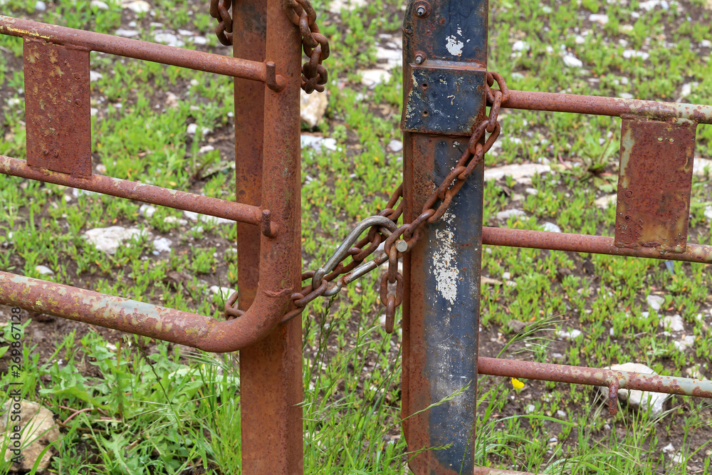 Rusty metal gates tied with metal chain