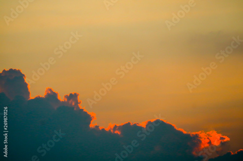 sunset sky back on dark silhouette cloud and orange of sun ray