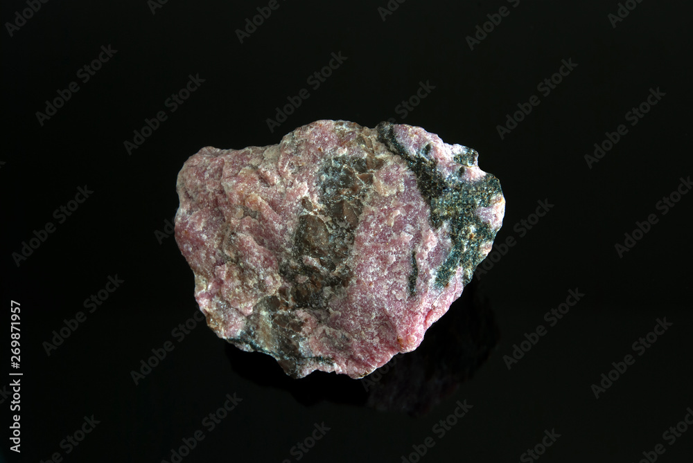 Macro stone Rhodonite mineral on a black background. Origin: Russia, Ural. Macro stone Rhodonite mineral on a black background. Origin: Russia, Ural.