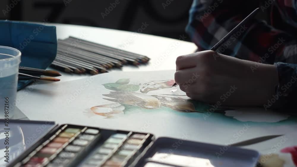 Drawing amazing birds with watercolor flowers on a paper sheet with a brush Drawing amazing birds with watercolor flowers on a paper sheet with a brush
