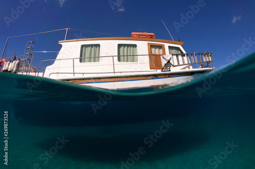 Underwater sea level photo of idilic pebble beach of Karavostasis, picturesque port of Folegandros island with traditional fishing boats docked and crystal clear turquoise sea, Cyclades, Greece photo