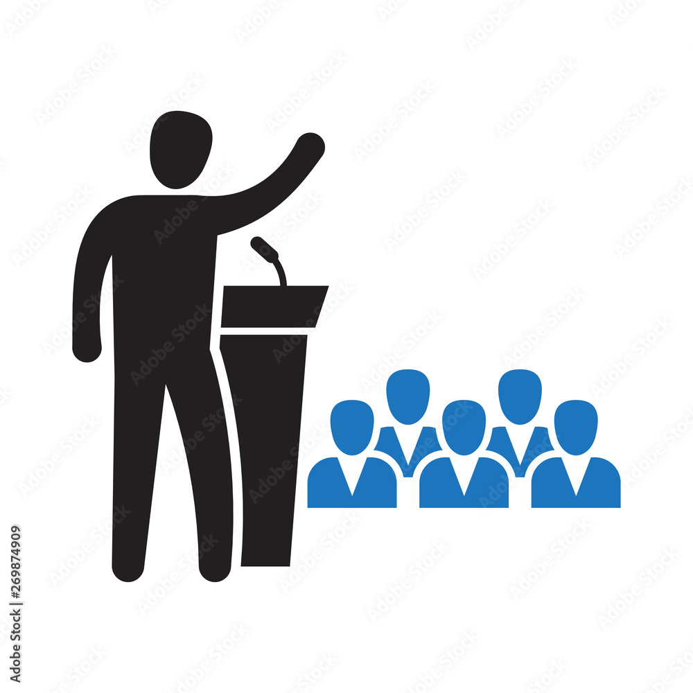 Public Speaker Standing Behind Rostrum Speaking To Gathered Public public-speaker-standing-behind-rostrum-speaking-to-gathered-public