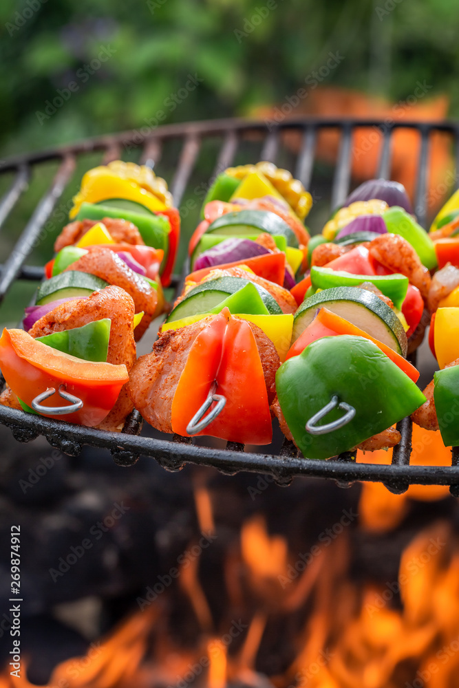 Closeup of skewers on grill with meat and vegetables