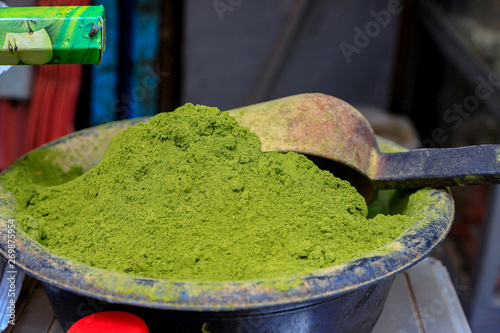 A heap of light green henna powder in a market stall in Meknès photo