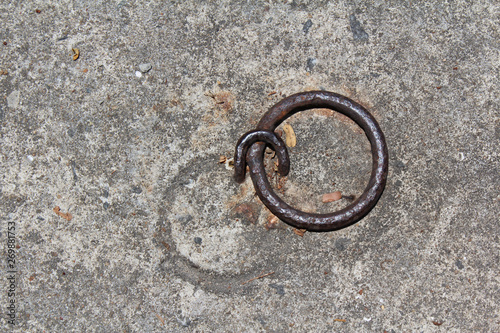 Concrete floor with iron rusty ring and loop.