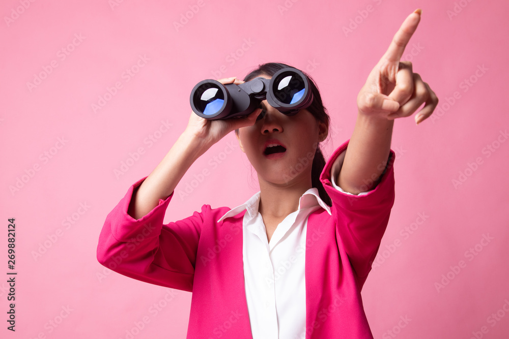 Young Asian woman  point and look with binoculars.