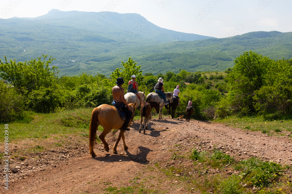 Group of tourists on the mountain equestrian trip on horses around the Ghost valley near Alushta, Crimea. Group of tourists on the mountain equestrian trip on horses around the Ghost valley near Alushta, Crimea.