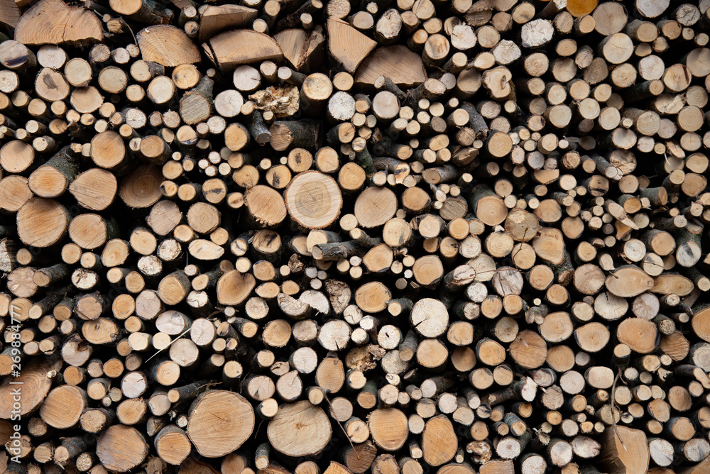 Stack of air-dried, home-made, hardwood firewood. A wall of wooden logs that form a background design. Stack of air-dried, home-made, hardwood firewood. A wall of wooden logs that form a background design.