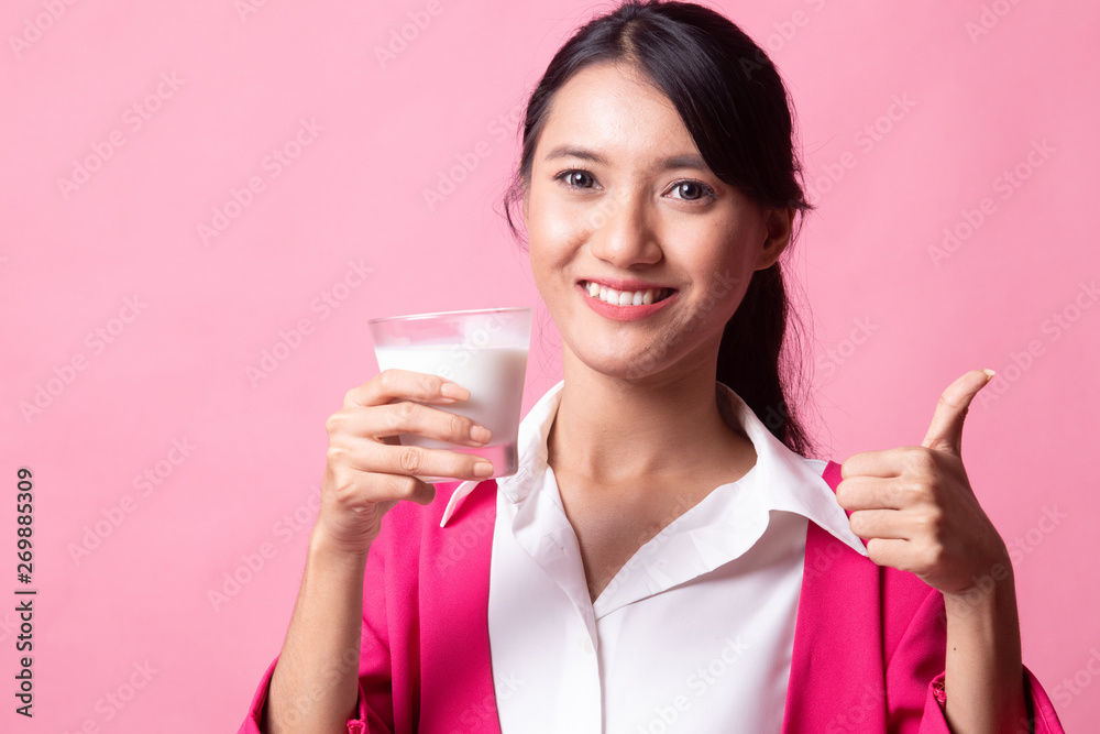 Healthy Asian woman drinking a glass of milk thumbs up. Healthy Asian woman drinking a glass of milk thumbs up.