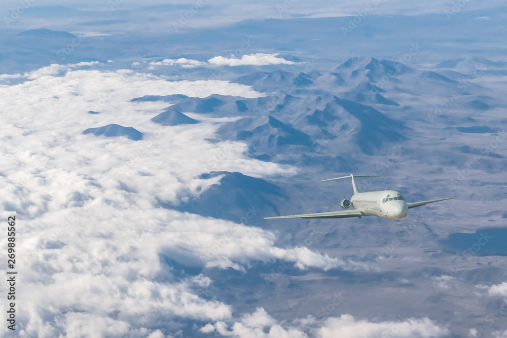 Fototapeta premium Commercial airplane flying above clouds