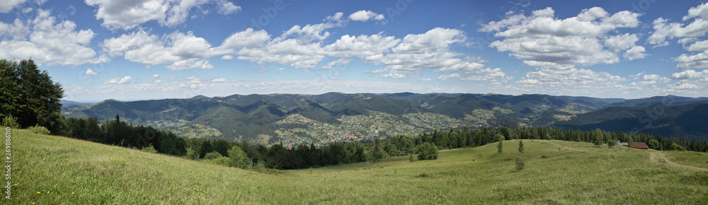 Beauty of the nature on Carpathian Mountains landscape: Svinyanka mountain view from the summit to the village Mykulichin. Panorama.