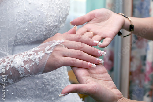 bridesmaid inspects the manicure of the bride. beauty and fashion in women's clothing.