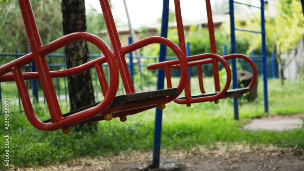 baby swing, after the rain in the park. Empty swing seats rocking on the playground in the park. baby swing, after the rain in the park. Empty swing seats rocking on the playground in the park.