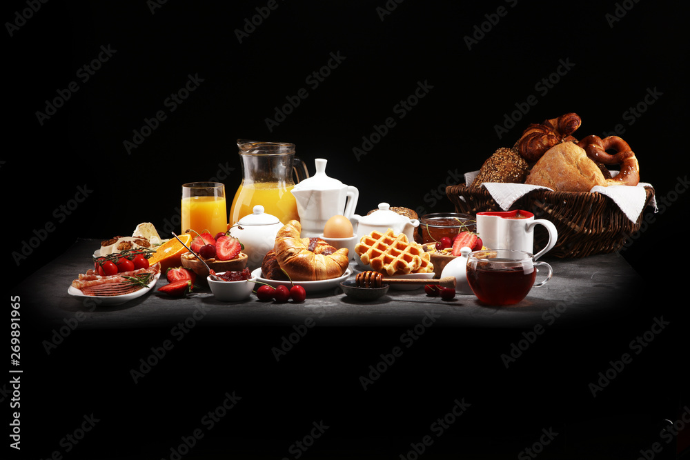 Huge healthy breakfast on table with coffee, orange juice, fruits, waffles and croissants. Good morning concept.