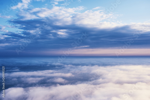 above the clouds cloudscape. cloudy weather in the mountains. blue sky aerial view background. © kravtzov
