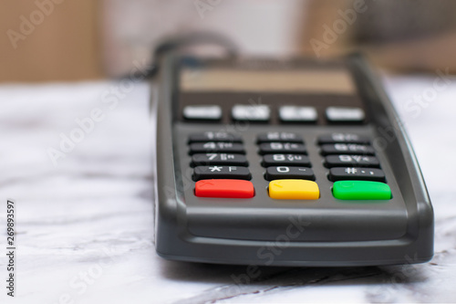 The credit card payment terminal is on the table in the store. Close-up of contactless payment device, card machine.