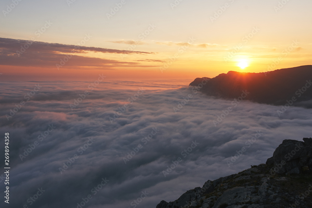 Fototapeta premium beautiful sunset above the clouds in the mountains. stunned landscape background with copy space. aerial mountain view