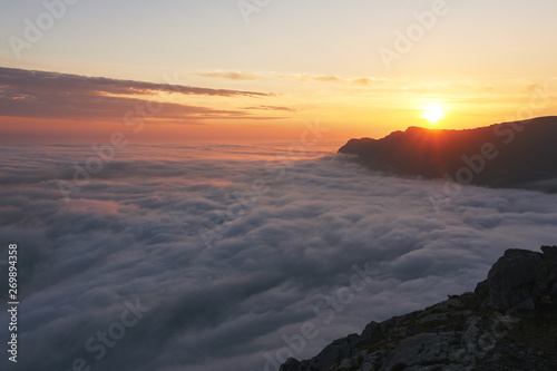 beautiful sunset above the clouds in the mountains. stunned landscape background with copy space. aerial mountain view