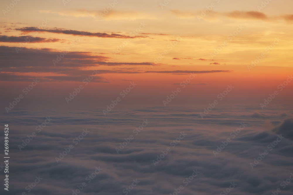 beautiful sunset above the clouds in the mountains. stunned landscape background with copy space. aerial mountain view