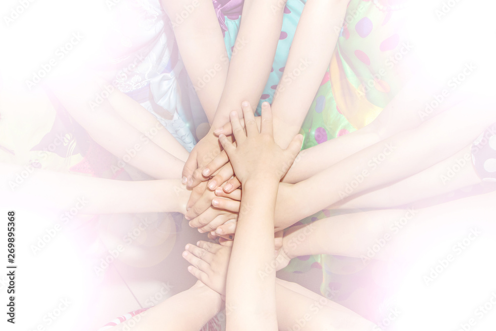 Naklejka premium Group of children putting their hands together. Concept teamwork partnership