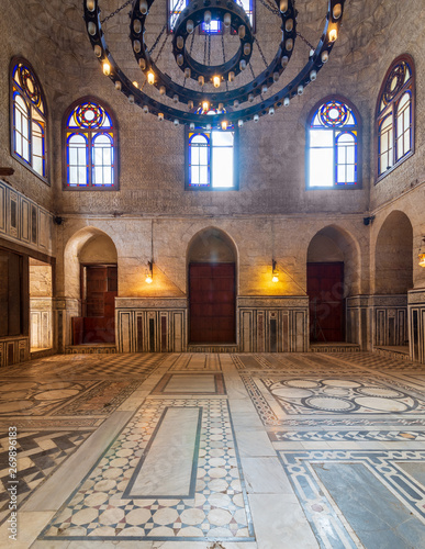 Interior shot of a hall at Mamluk era Sultan al Ghuri Mausoleum with decorated marble floor, stained glass windows, and bricks stone wall, Cairo, Egypt