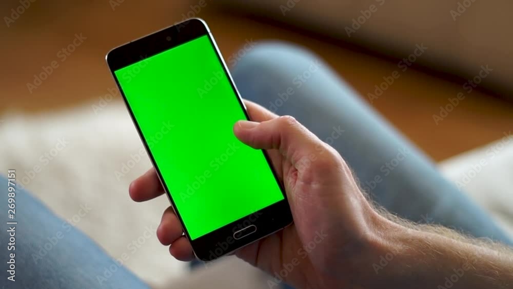 Male hand swiping up on a phone with a green screen