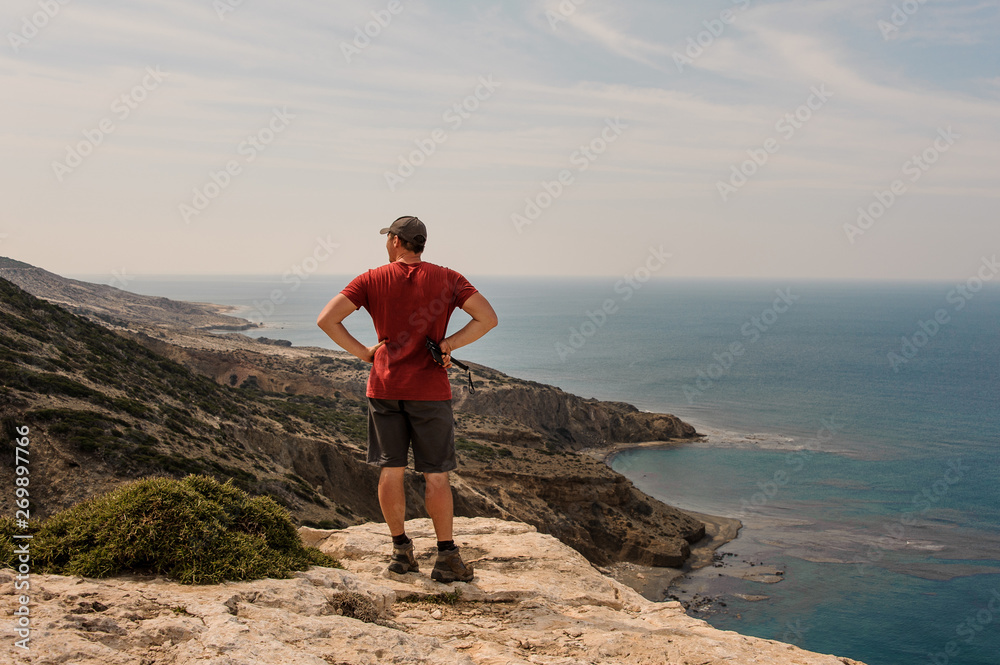 Man standing and looking on the hills and sea