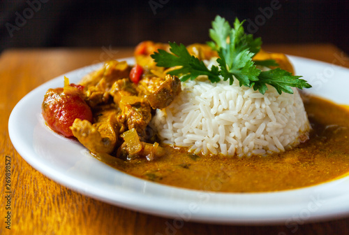 Εκτύπωση καμβά Curry chicken bright juicy with white rice on plate over wooden background