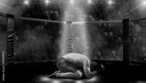 Mixed martial arts fighter (MMA) lies in octagon