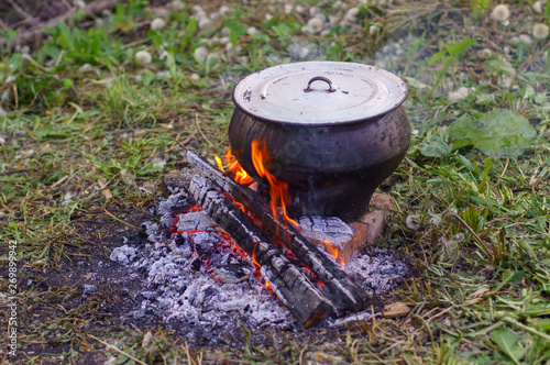 Cast iron on the fire, close-up. People resting in nature, lit a fire and cooked on it in fish soup.