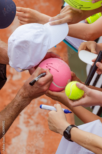 Tennis player signs autograph after win