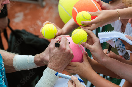 Tennis player signs autograph after win