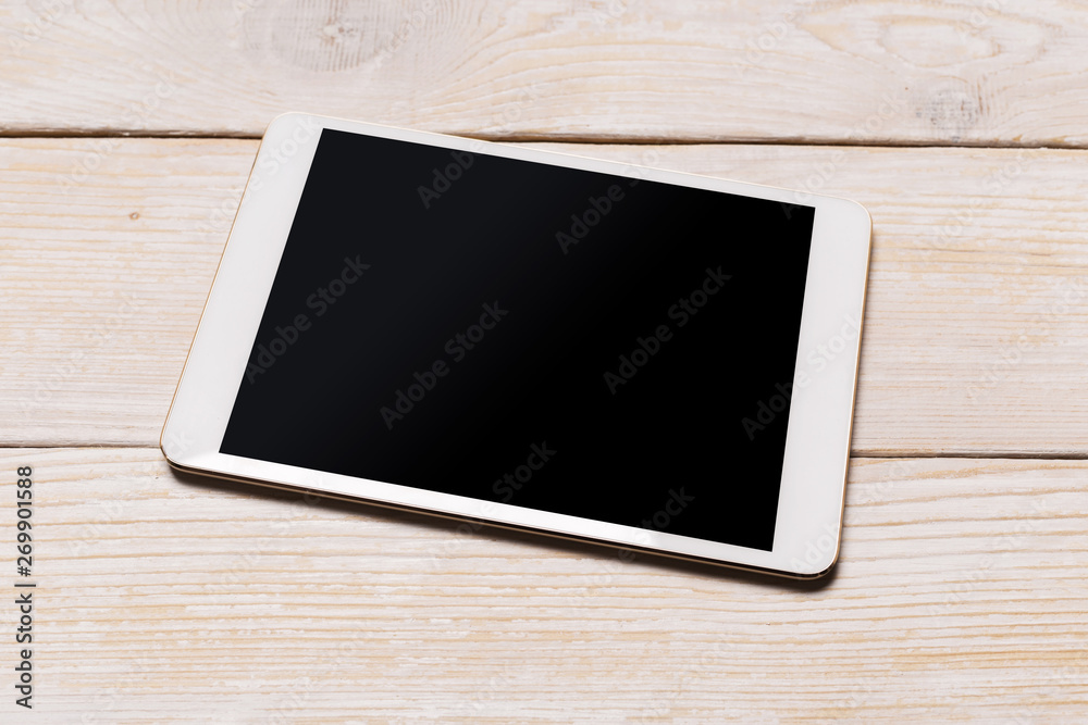 White digital tablet on wooden table. Top view with copy space. White digital tablet on wooden table. Top view with copy space.