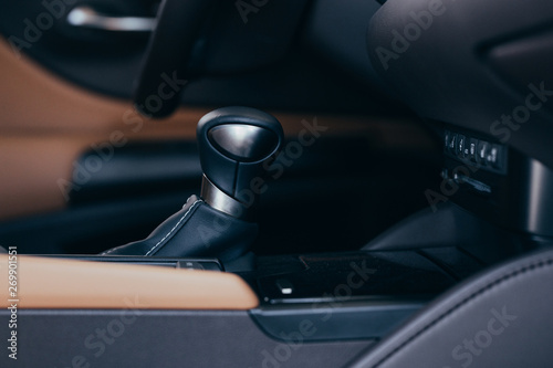 Selector automatic transmission with perforated leather in the interior of a modern expensive car. The background is blurred