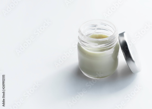 glass jar with cosmetic cream on a light background. copy space