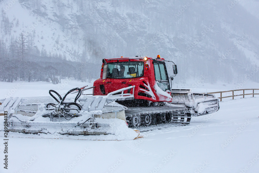 Trail groomer machine in Alps after snow blizzard Trail groomer machine in Alps after snow blizzard
