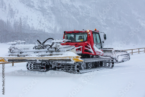 Trail groomer machine in Alps after snow blizzard