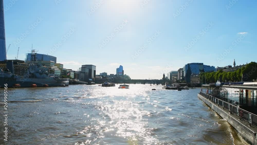 Panning Thames river from Tower pier with wide angle panoramic view of London bridge with cityscape skyline of business financial city center in summer in London UK Panning Thames river from Tower pier with wide angle panoramic view of London bridge with cityscape skyline of business financial city center in summer in London UK