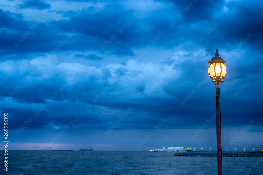 Light Post at nigth near sea with stom background
