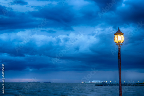 Light Post at nigth near sea with stom background