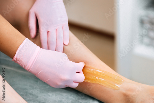 Sugaring Sugar waxing feet in the beauty salon. photo