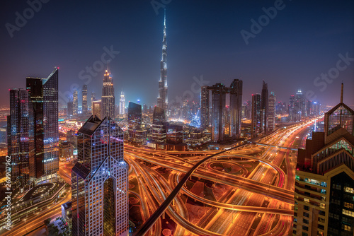 Dubai skyline during sunrise with shining traffic road, United Arab Emirates.