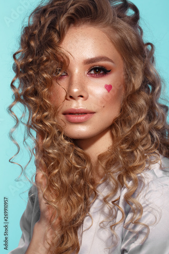 Pretty girl with curls hairstyle, classic makeup, freckles, nude lips Beauty face.
