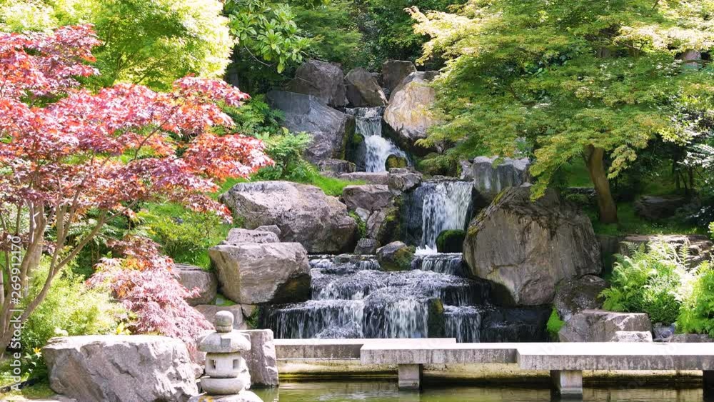 Waterfall with maple trees in Kyoto Japanese Garden in Holland Park green summer peaceful zen lake pond water and green trees in London, UK with nobody Waterfall with maple trees in Kyoto Japanese Garden in Holland Park green summer peaceful zen lake pond water and green trees in London, UK with nobody