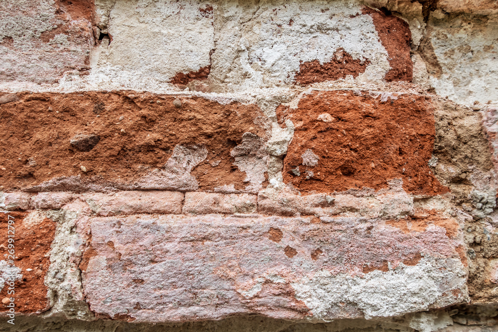 abstract background of an old brick wall with peeling plaster and the remains of pink paint close up abstract background of an old brick wall with peeling plaster and the remains of pink paint close up